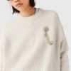 Pullover mit Blumenbrosche